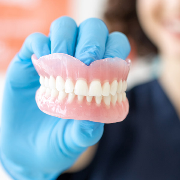 dentist holding dentures